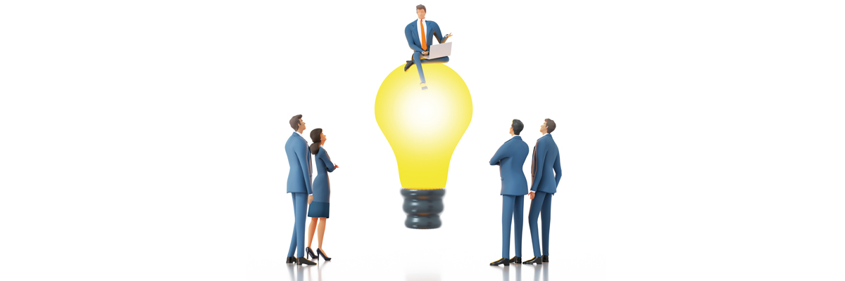 Equipo empresarial alrededor de una bombilla iluminada, símbolo de innovación, liderazgo y generación de ideas de negocio.