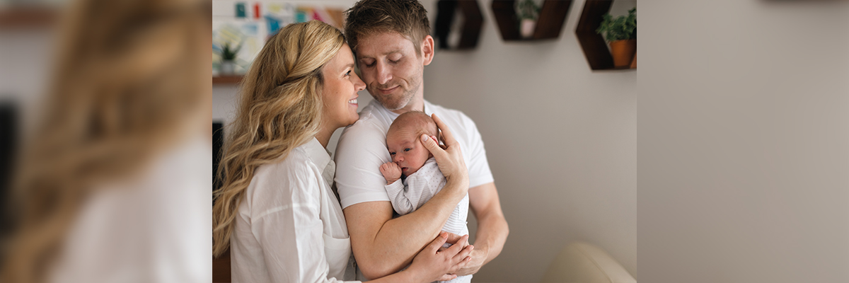 Foto de madre, padre y bebe entre los brazos del padre