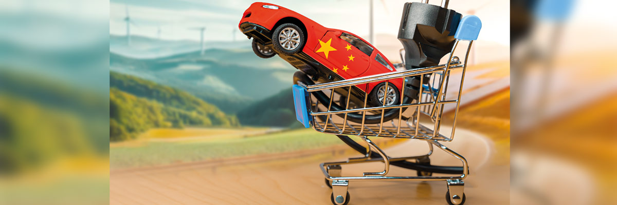 Coche de juguete con bandera de China dentro de un carrito de la compra sobre un fondo borroso de paisaje