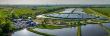 La imagen muestra una vista aérea de un parque solar y aerogeneradores, simbolizando un futuro sostenible con energías renovables