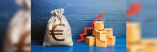 Saco de rafia con el símbolo de euro y cajas de mercancia junto a una felcha roja de inflacción