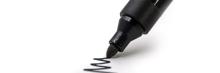 Punta de rotulador negro trazando una línea zigzagueante sobre papel blanco