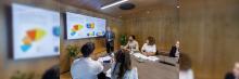 Un profesional presenta gráficos y datos en una sala de juntas moderna, destacando una discusión interactiva sobre estrategias empresariales