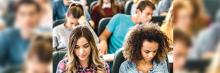 Estudiantes en un aula universitaria sentados en fila, concentrados en sus apuntes