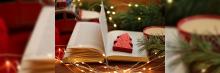 Un libro abierto adornado con una decoración navideña en forma de árbol, rodeado de luces festivas, evoca la calidez y la alegría de las vacaciones