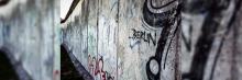 Una sección del Muro de Berlín, marcada con graffiti colorido y la palabra ‘BERLIN’, simbolizando la historia y cultura vibrante que emergió a pesar de la división