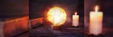 Una escena mística que muestra un antiguo libro, una bola de cristal radiante que emana destellos de luz y dos velas encendidas sobre una superficie de madera